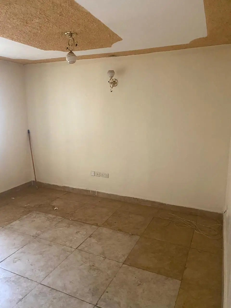 Empty living space with exposed ceiling beams, ceramic tile flooring
