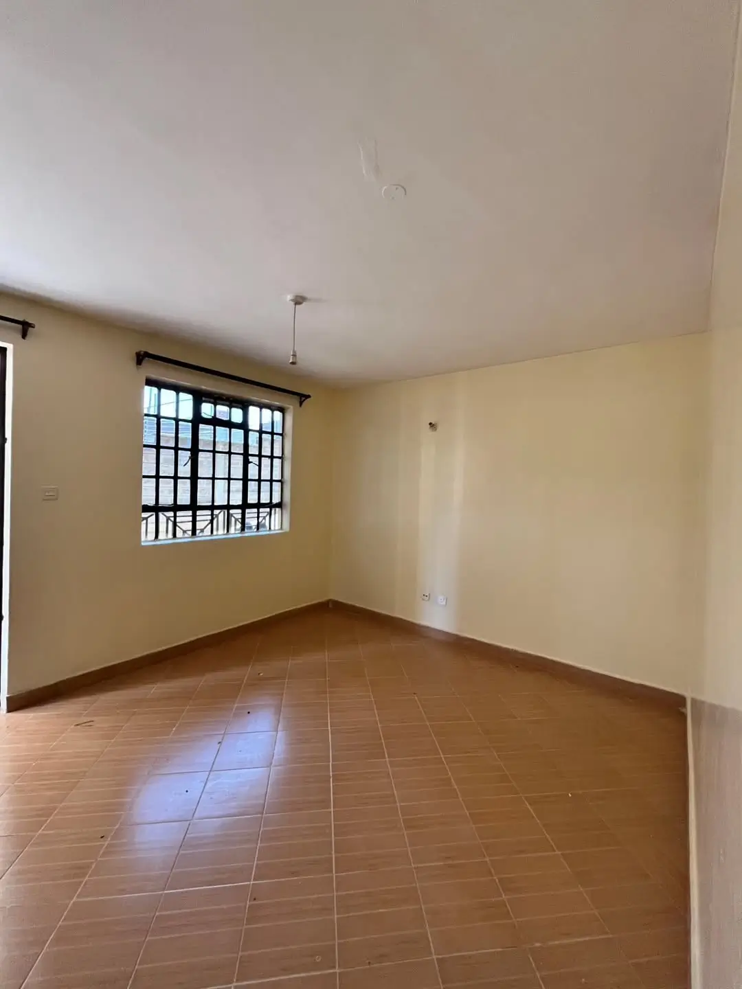 Spacious empty living room with terracotta tile flooring