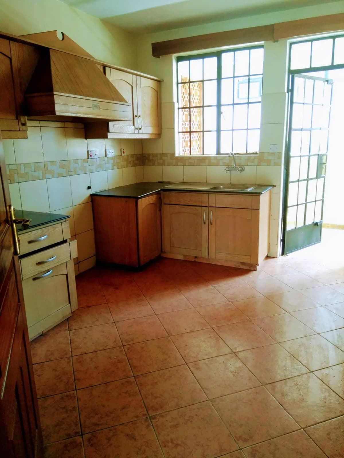 Spacious kitchen with wooden cabinets and large windows