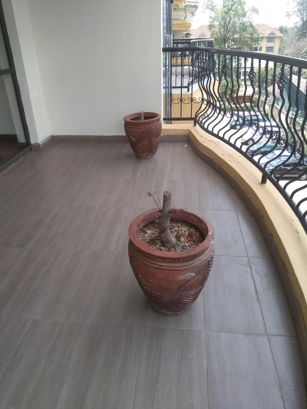Spacious balcony with potted plants and city view