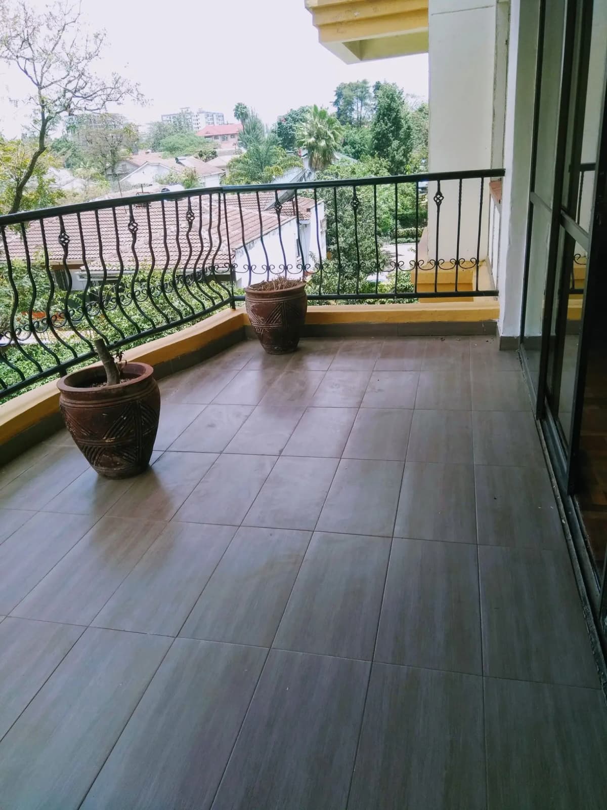 Spacious balcony with tiled floor and garden views