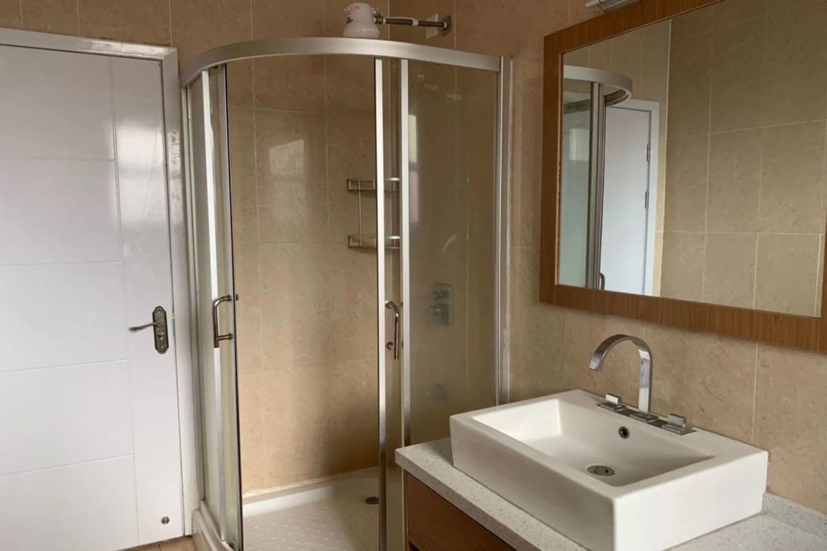 Modern bathroom with glass shower enclosure and wall-mounted sink