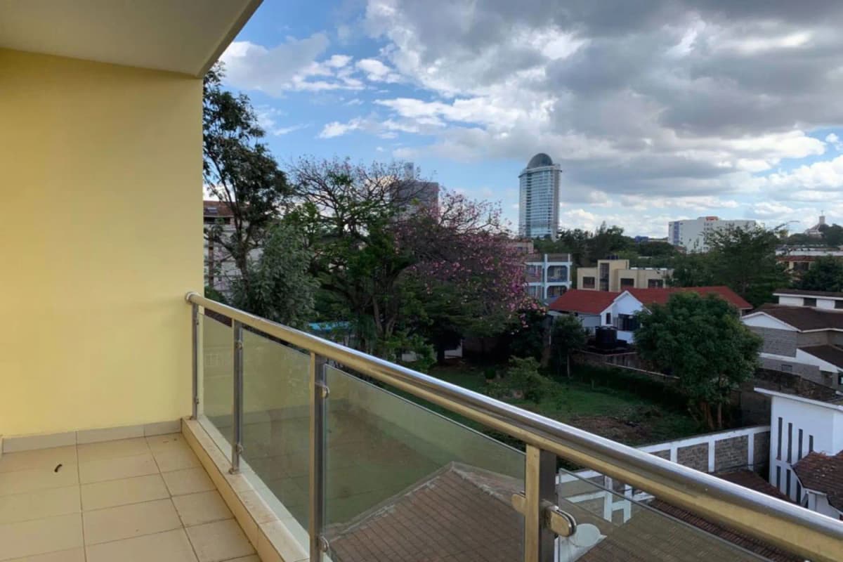 Spacious balcony with city skyline and tree-line views