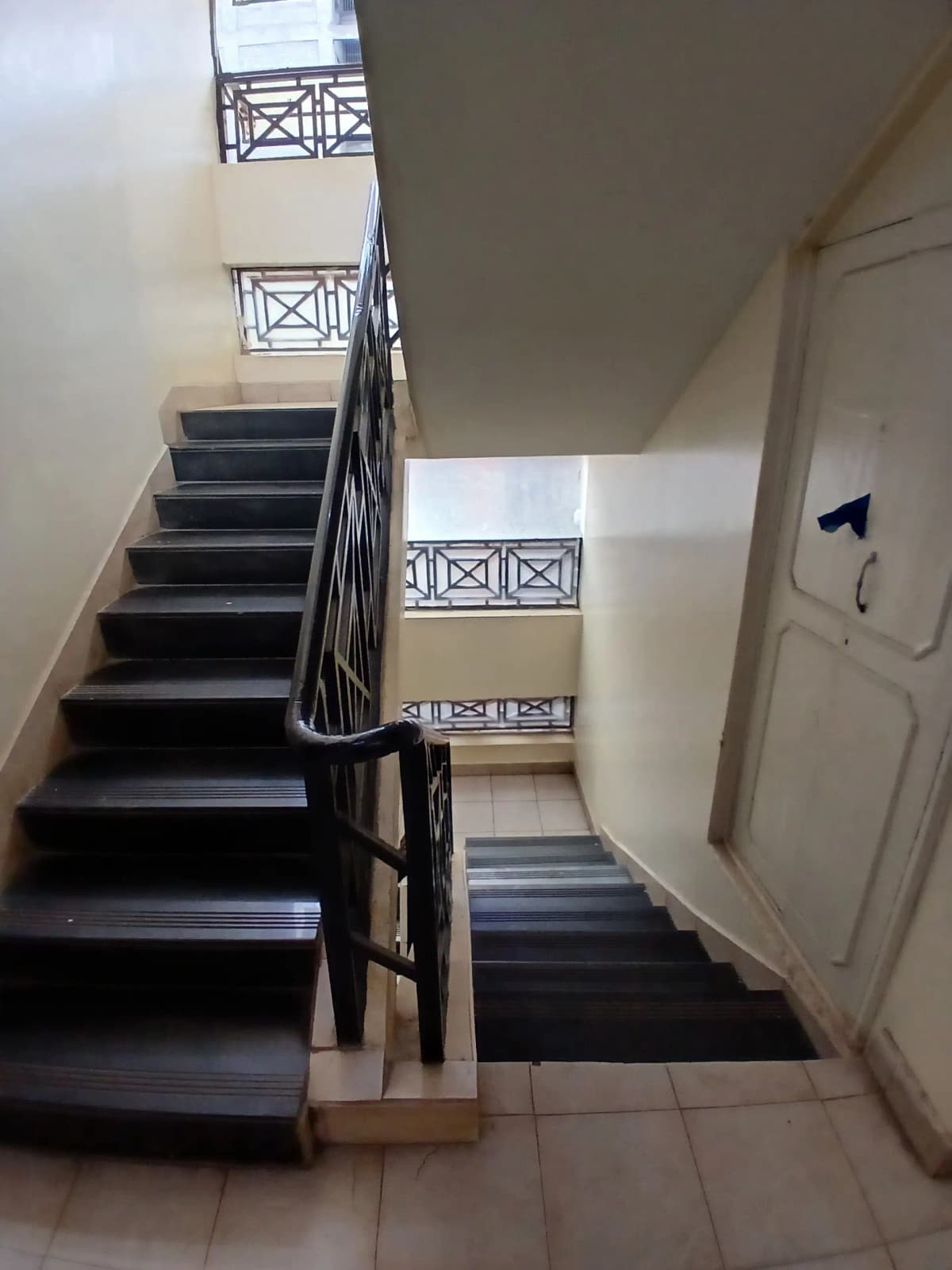 Multi-story stairwell with black metal railings and landing