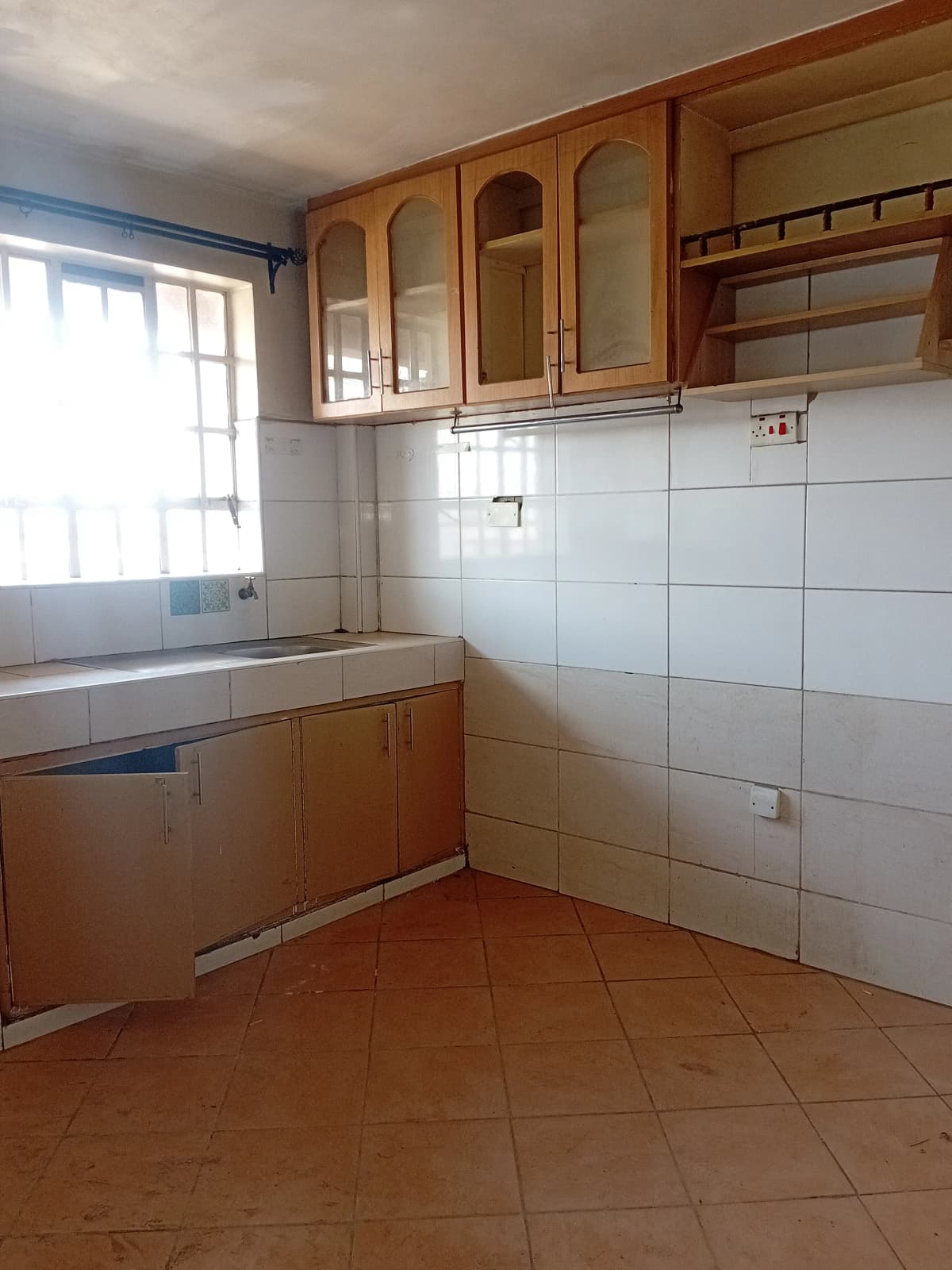 Compact kitchen with wooden cabinets, white tile backsplash