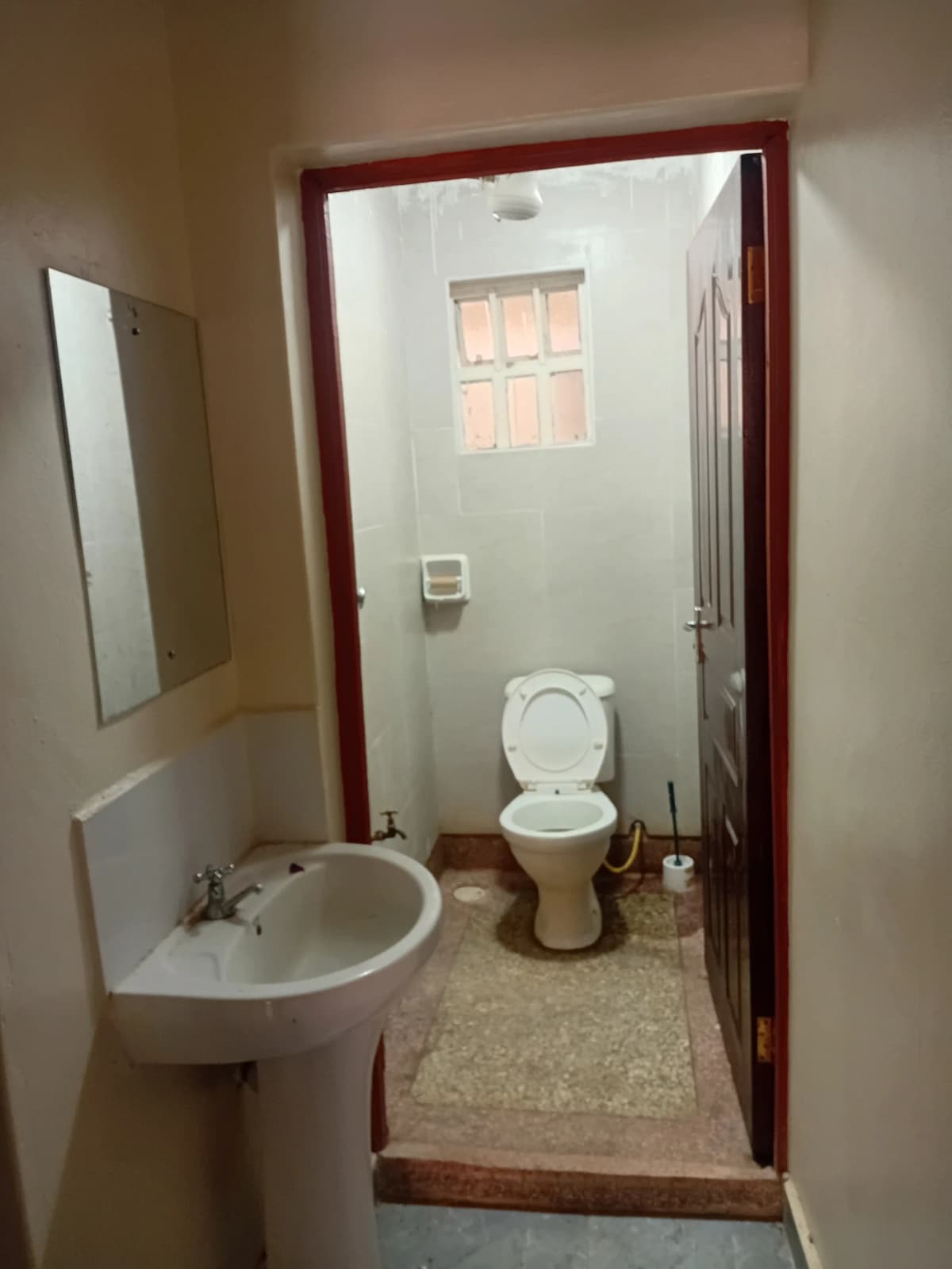 Compact bathroom with sink, toilet, and window