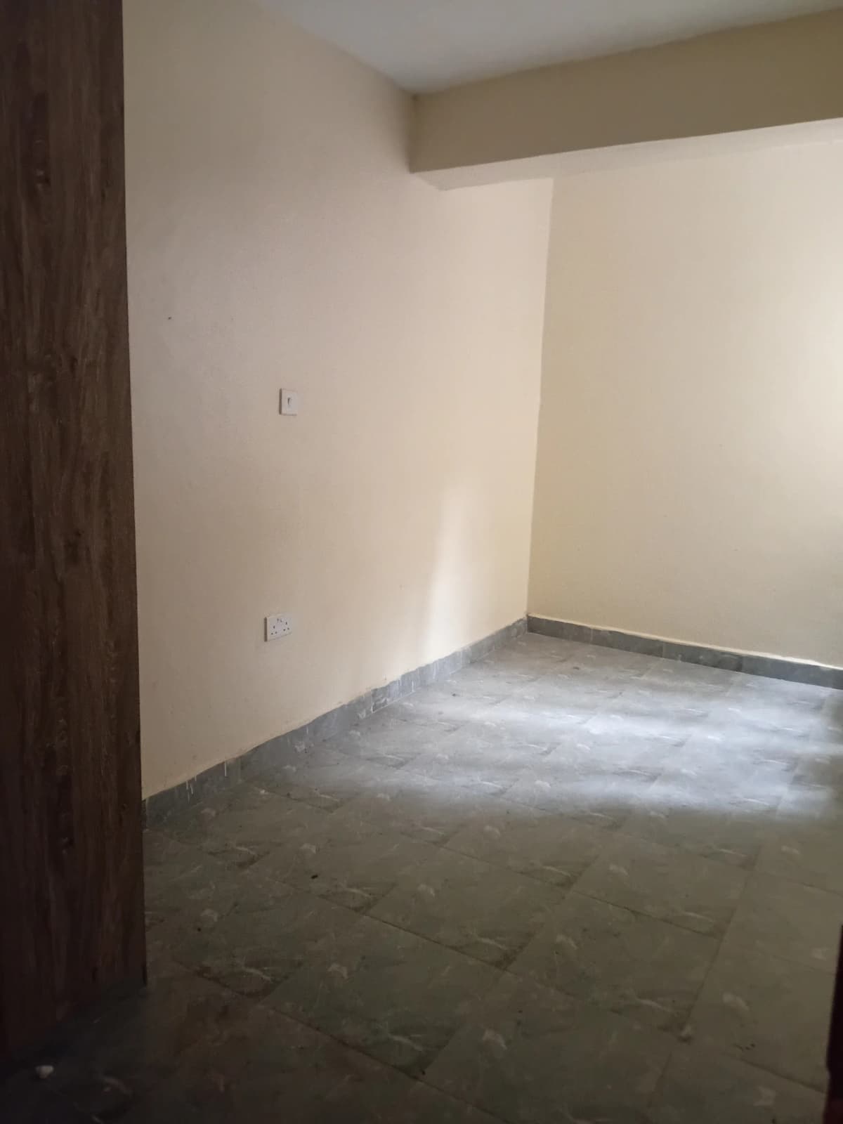 Empty living room with plain walls and concrete flooring
