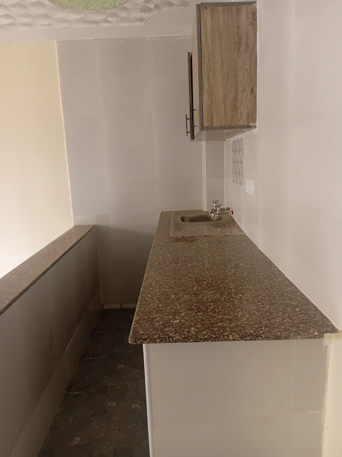 Compact kitchen with granite countertop and wall cabinet