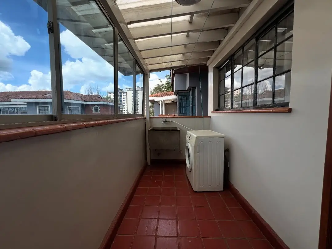 Enclosed laundry area with washing machine and city views