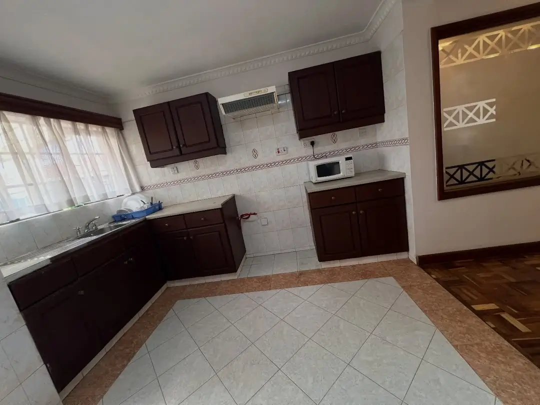 Modern kitchen with dark cabinets, tiled floors, open layout