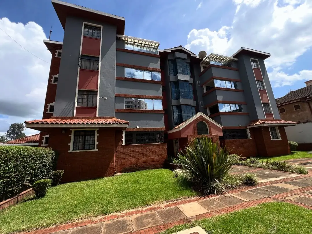 Modern multi-story residential building with manicured grounds