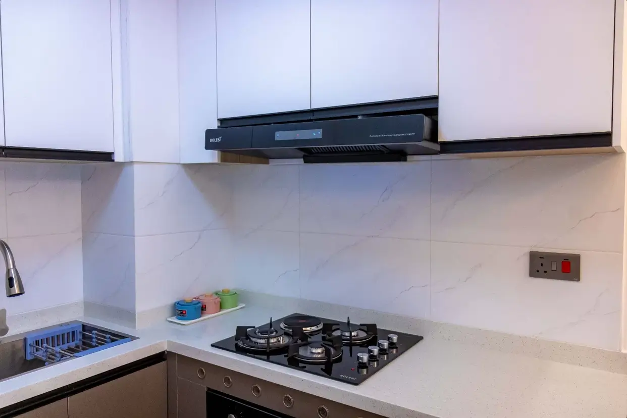 Modern kitchen with gas cooktop, hood extractor, white cabinetry