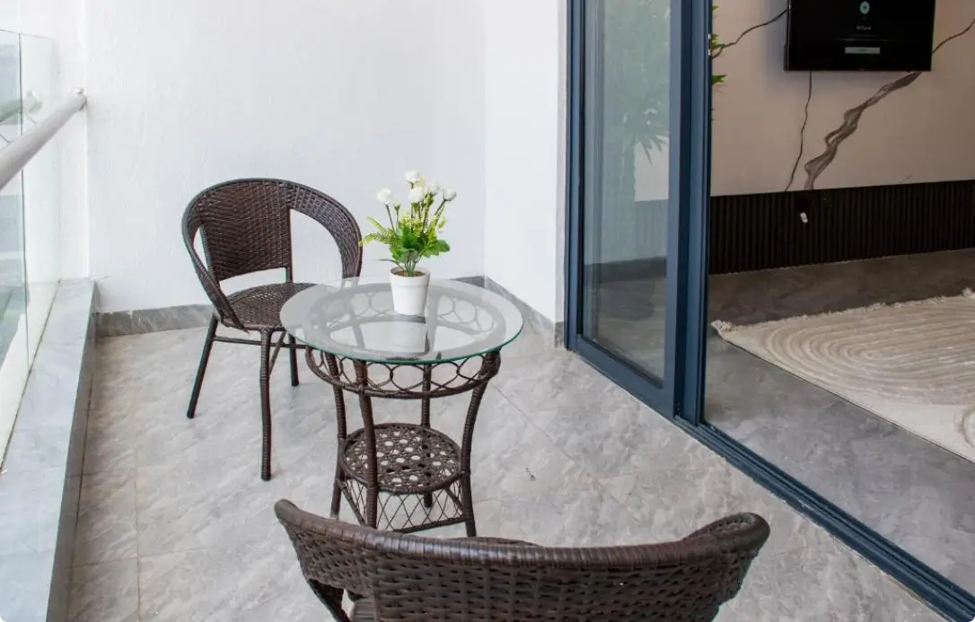 Compact balcony with wicker seating and glass table
