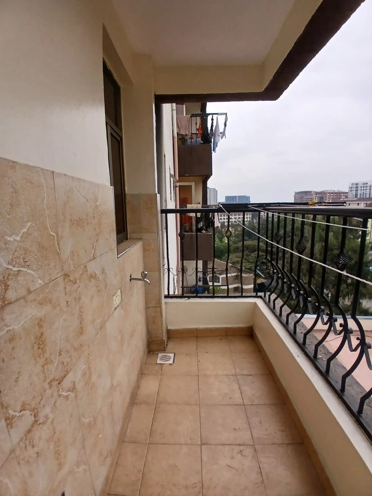Covered balcony with city skyline views and metal railings