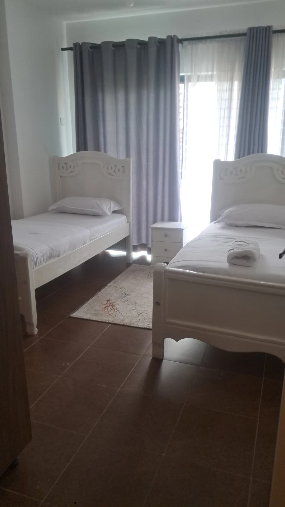 Bright bedroom with two single beds and balcony access