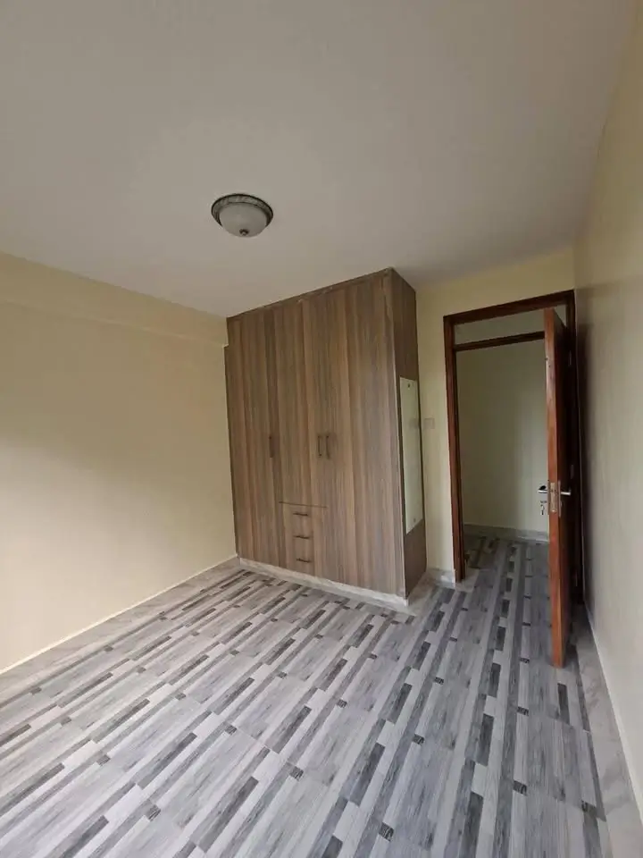Spacious bedroom with wooden wardrobe and striped flooring