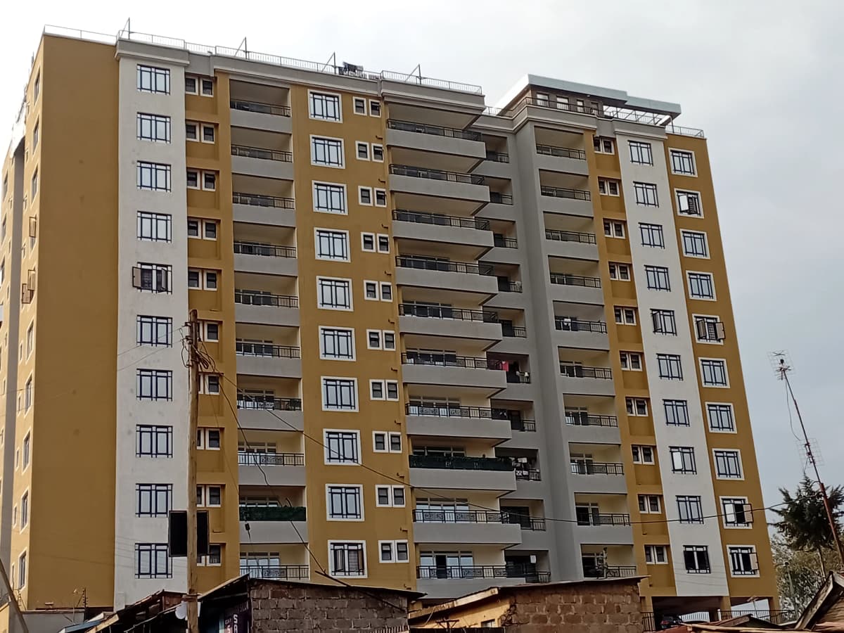 Multi-story residential apartment building with balconies and yellow facade