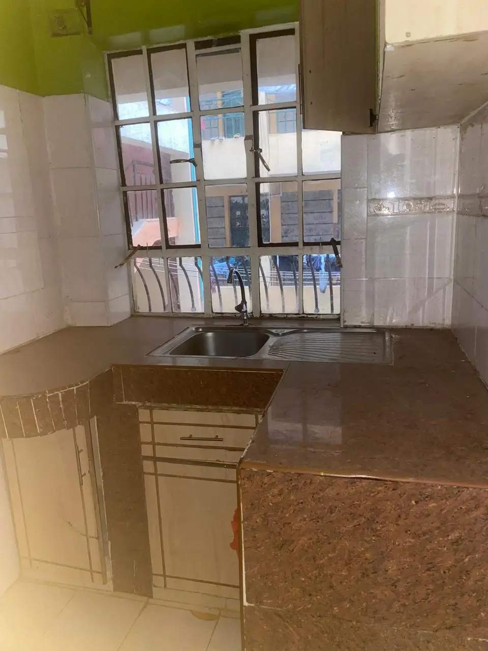 Compact kitchen with sink, counter space, and window view
