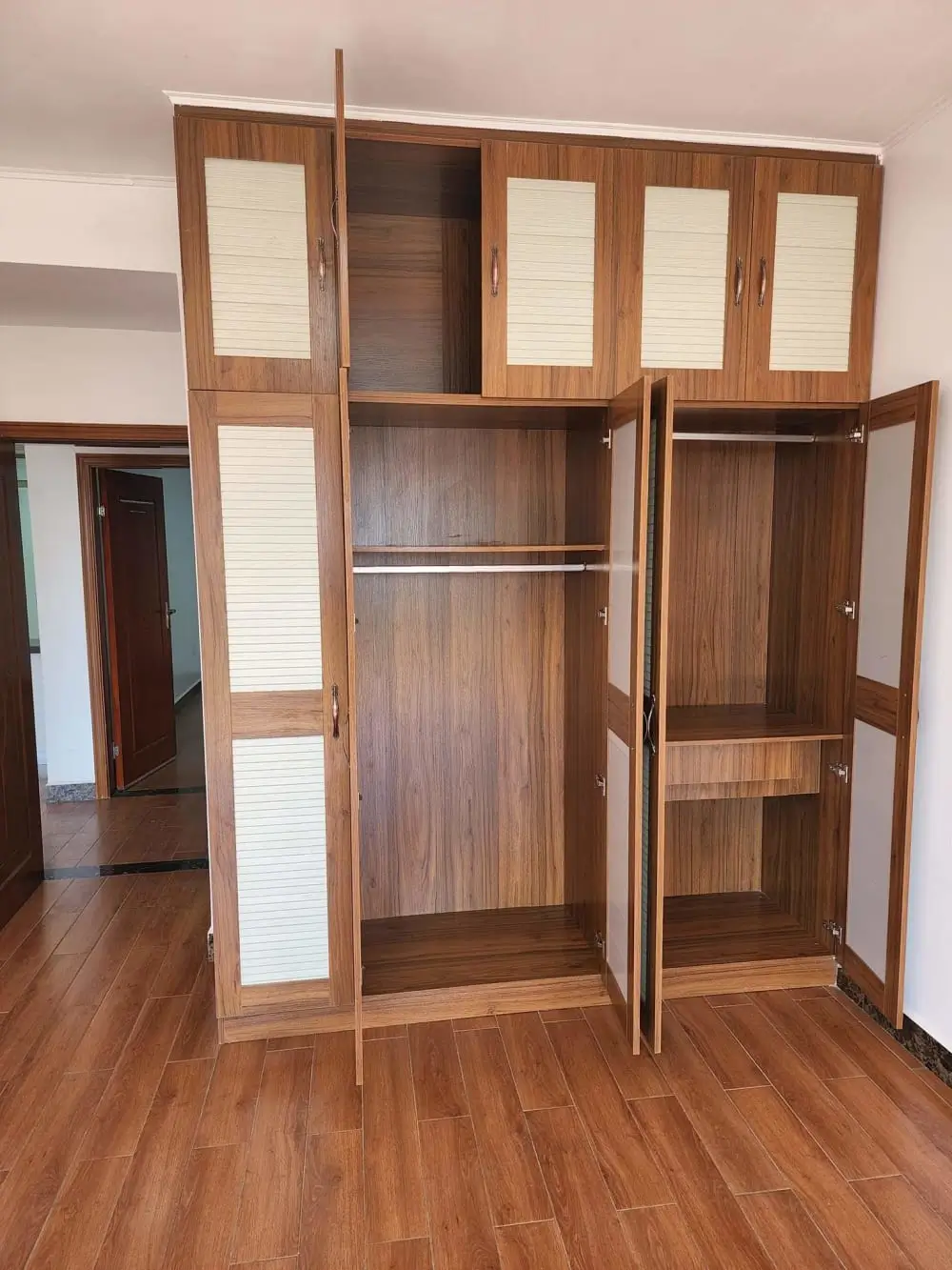 Spacious bedroom with wooden built-in wardrobe and shelving