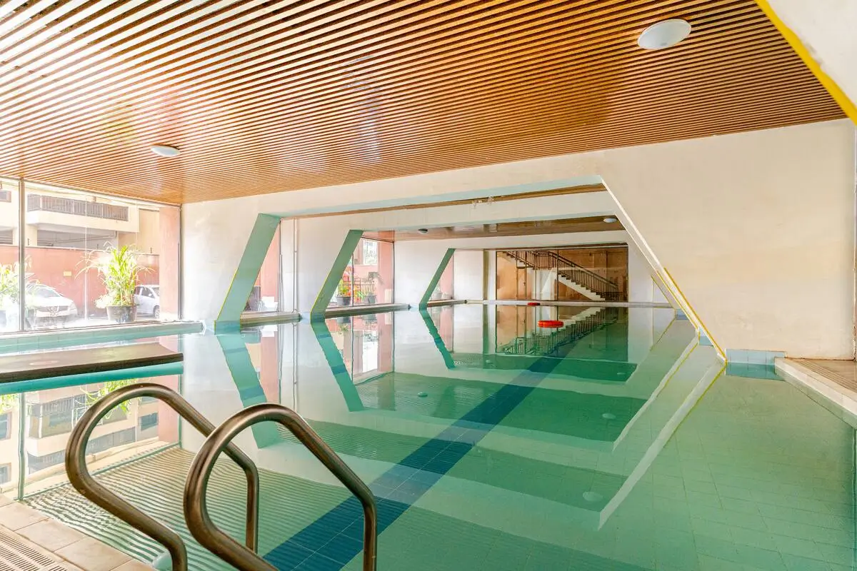 Indoor swimming pool with geometric lane dividers and metal railings