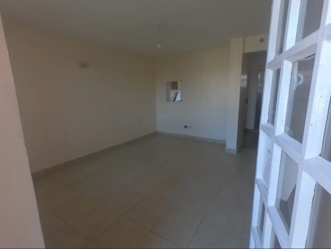 Empty living room with polished concrete floor and bright windows