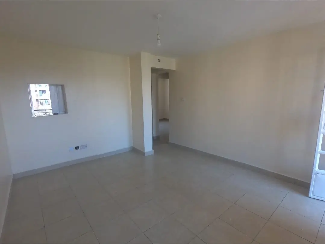 Empty living room with polished concrete floor and natural light