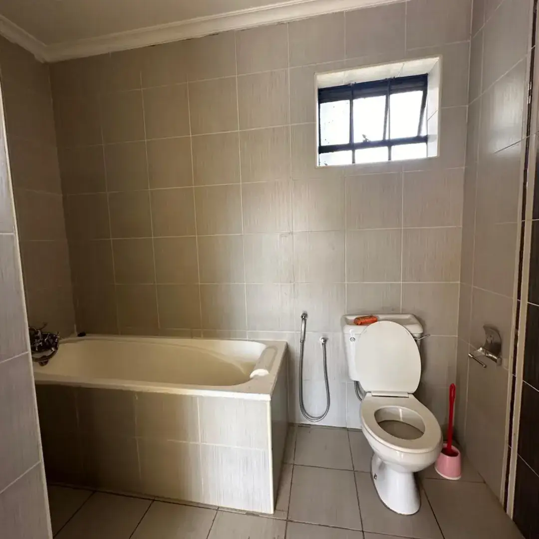 Bathroom with bathtub, toilet, and high window