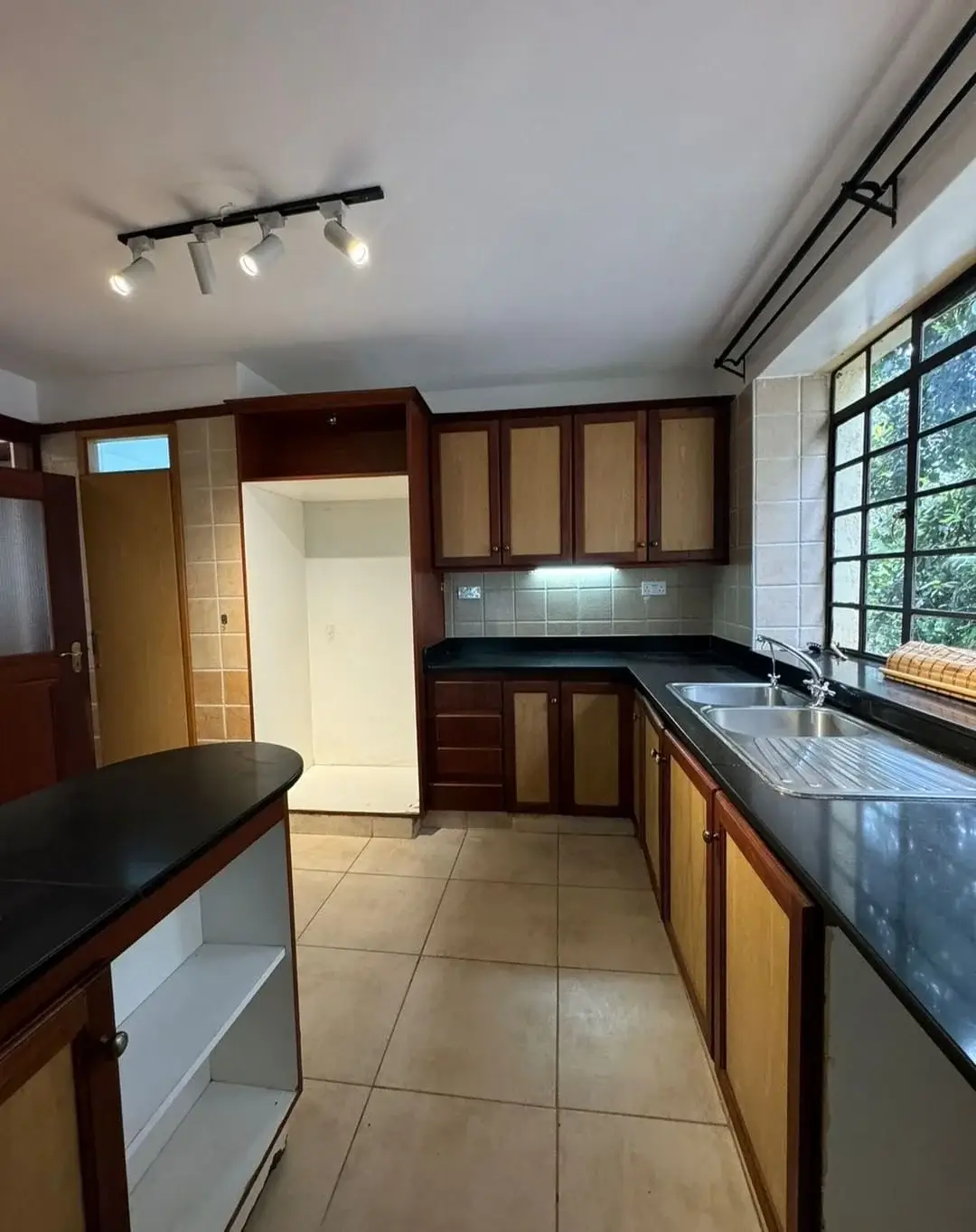 Modern kitchen with dark cabinetry, granite countertops, window views