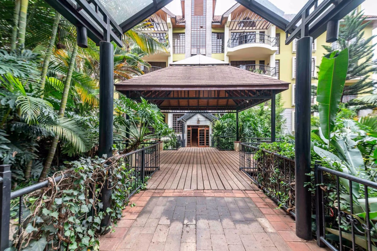 Covered wooden deck with lush tropical plants and railings