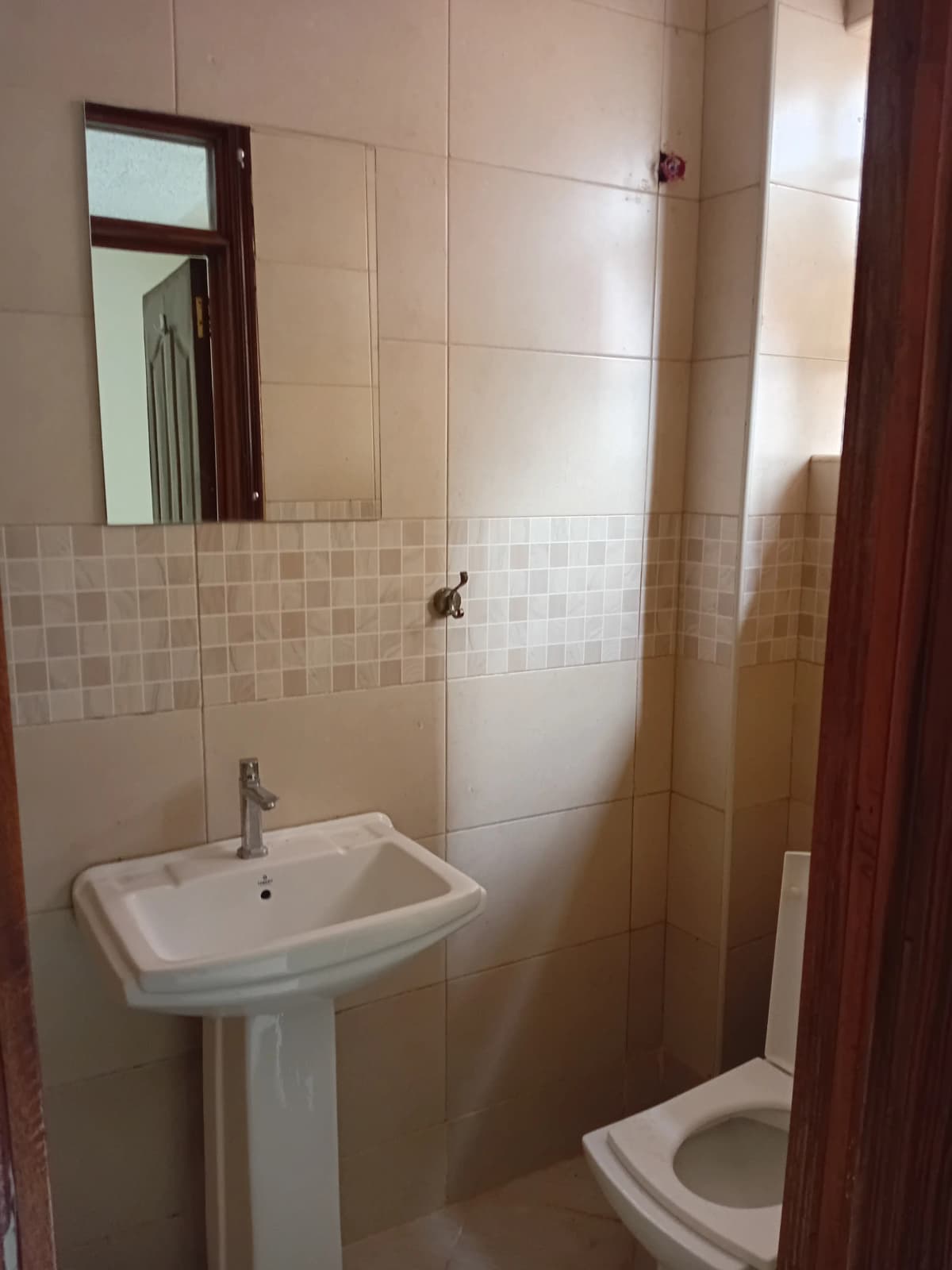 Simple bathroom with pedestal sink, toilet, and shower enclosure