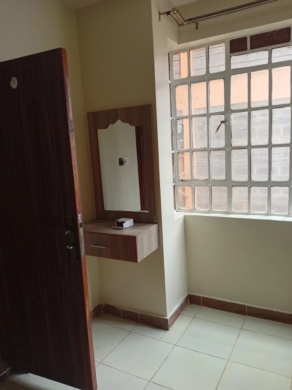 Bedroom with built-in vanity, mirror, and barred window