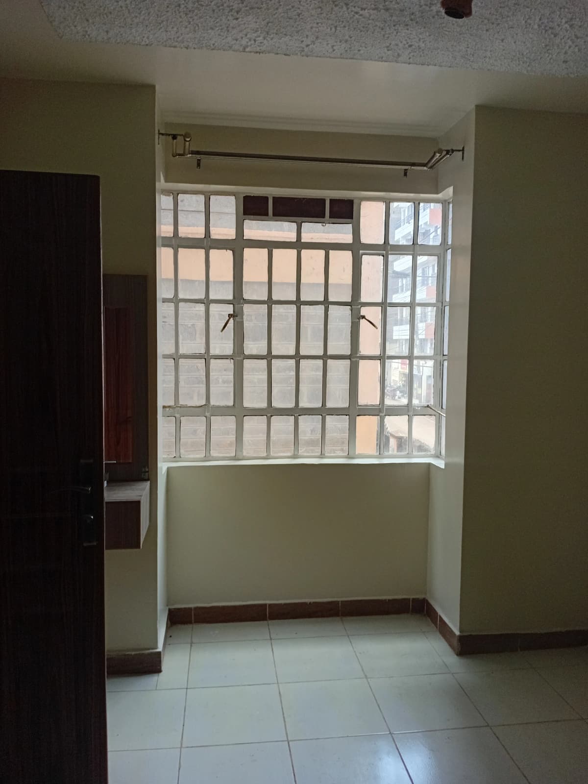 Building corridor with barred window and tiled flooring