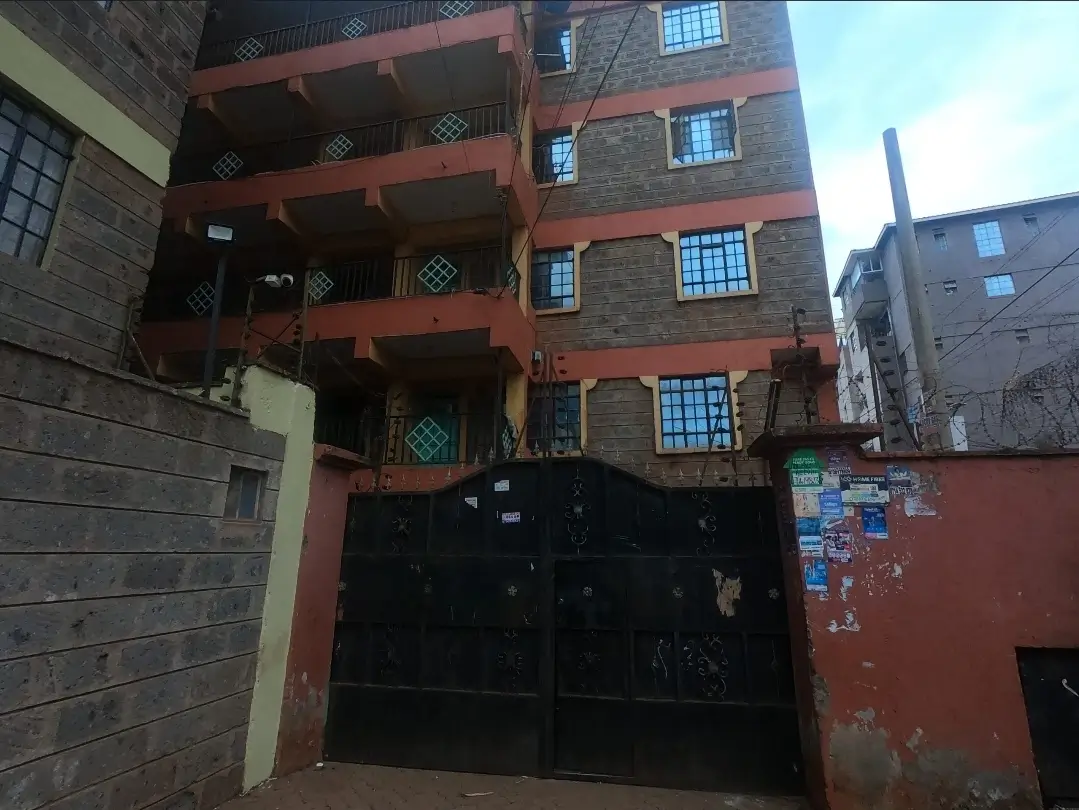 Multi-story residential building with red-brown facade and balconies