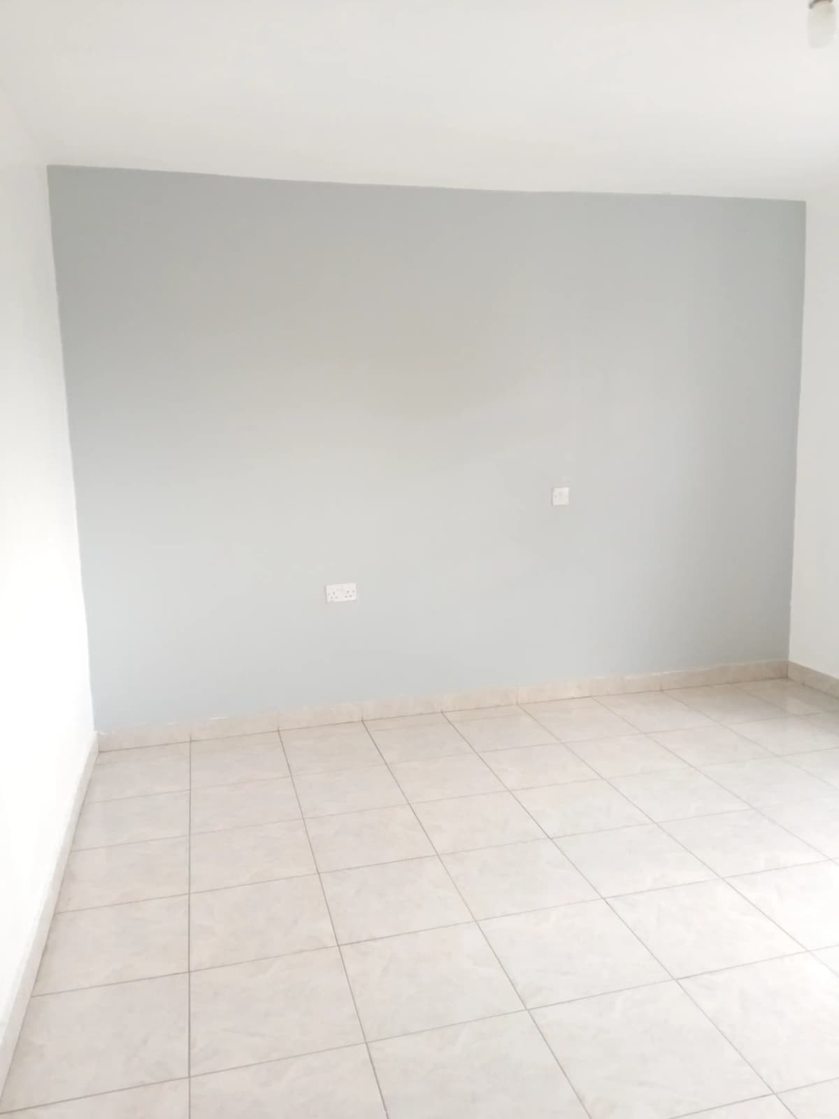 Empty room with light tile flooring and plain white walls