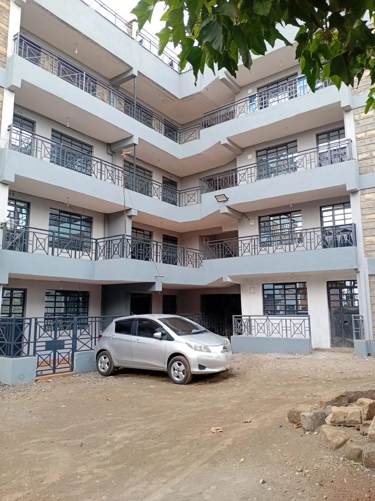 Multi-story residential building with ground-level parking bay