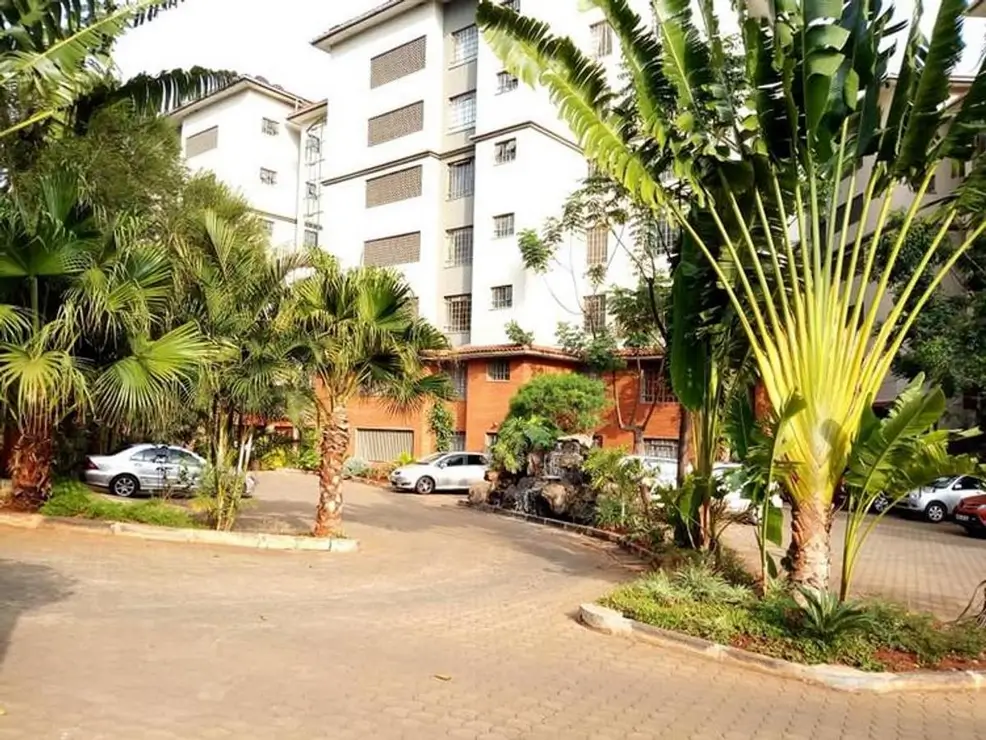 Compound entrance with parking bays and tropical landscaping
