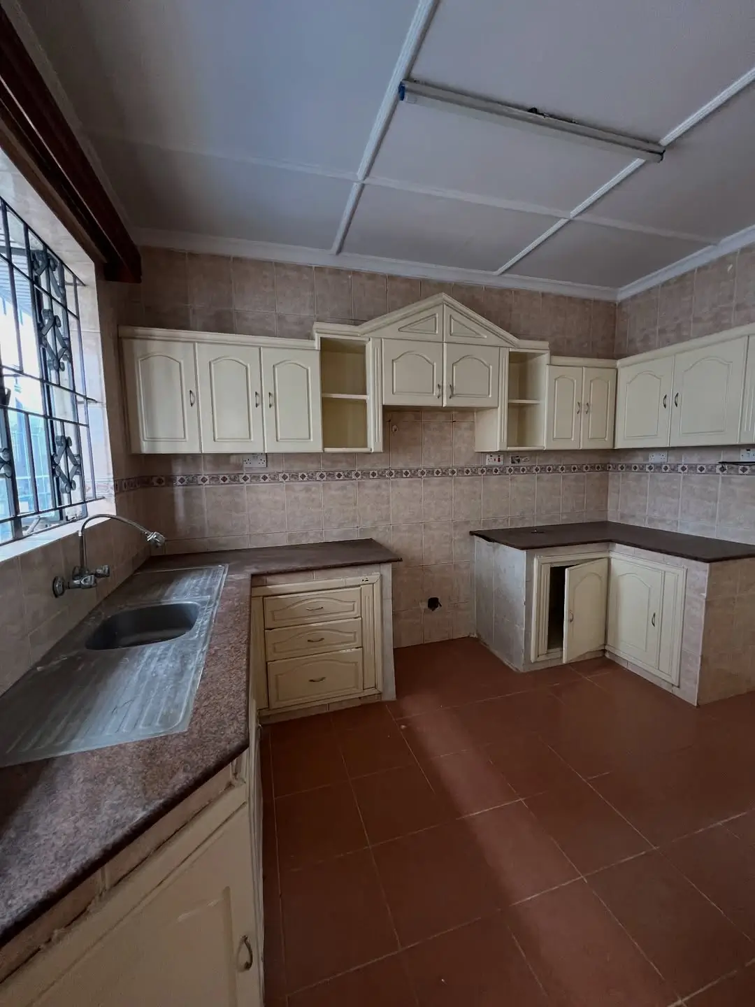 Spacious kitchen with cream cabinetry and dark countertops