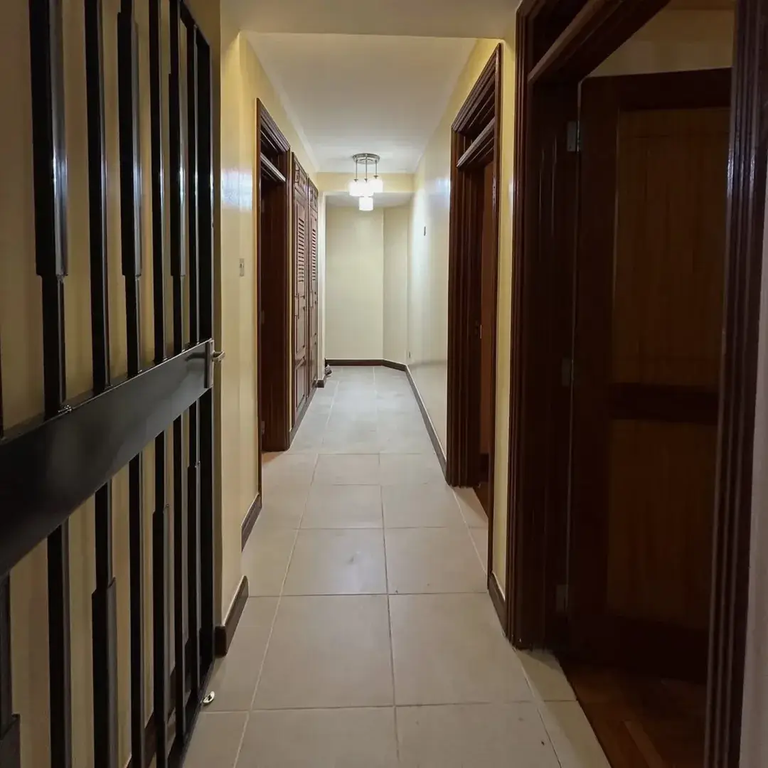 Long corridor with dark wooden doors and cream walls