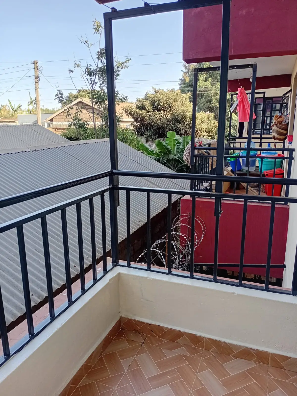 Modern balcony with black railings overlooking residential area