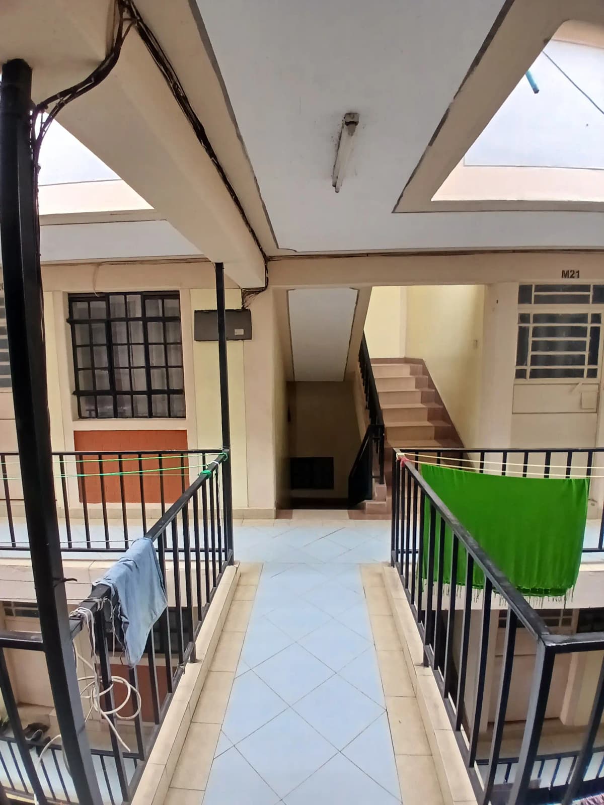 Multi-level building corridor with stairs and metal railings
