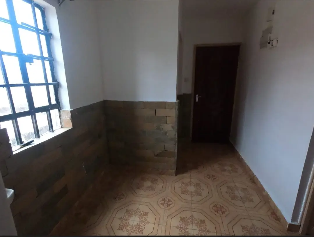 Unfurnished bedroom with patterned tile flooring and natural light