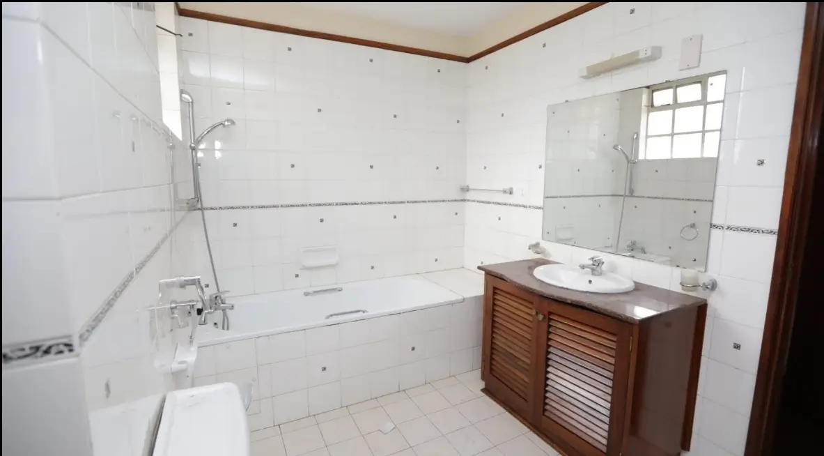 Spacious bathroom with wooden vanity and bathtub