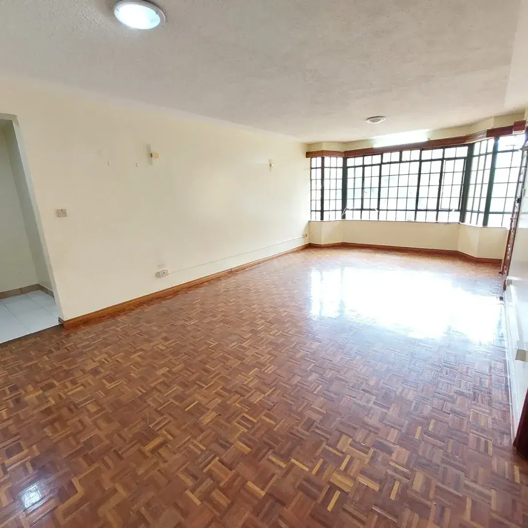 Spacious living room with herringbone wood flooring and natural light