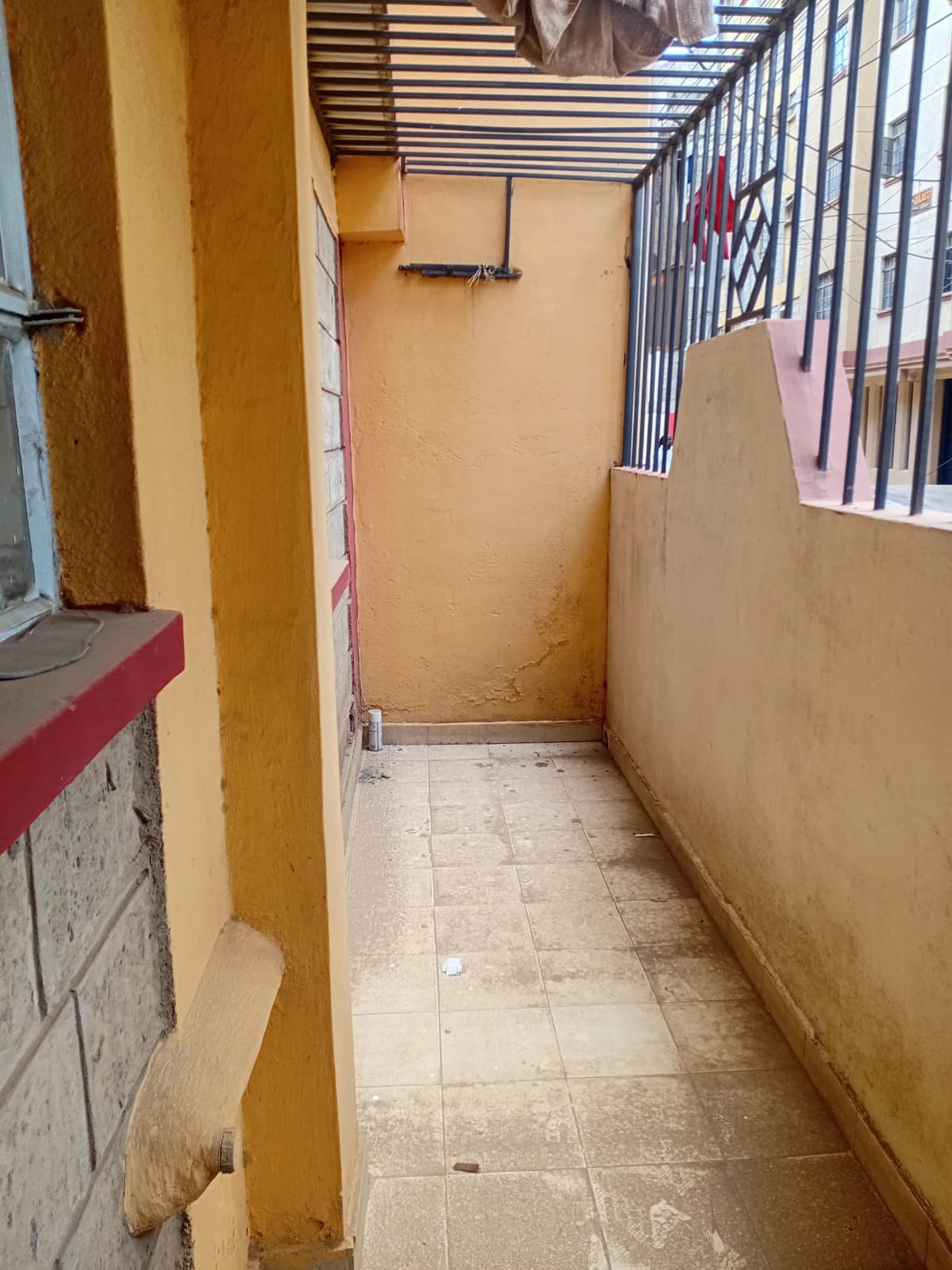 Narrow covered balcony or terrace with yellow walls