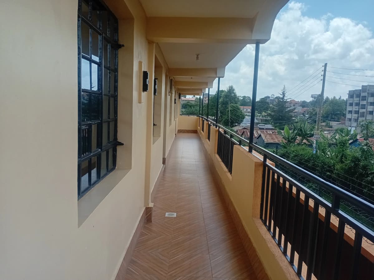 Long covered balcony with city and garden views