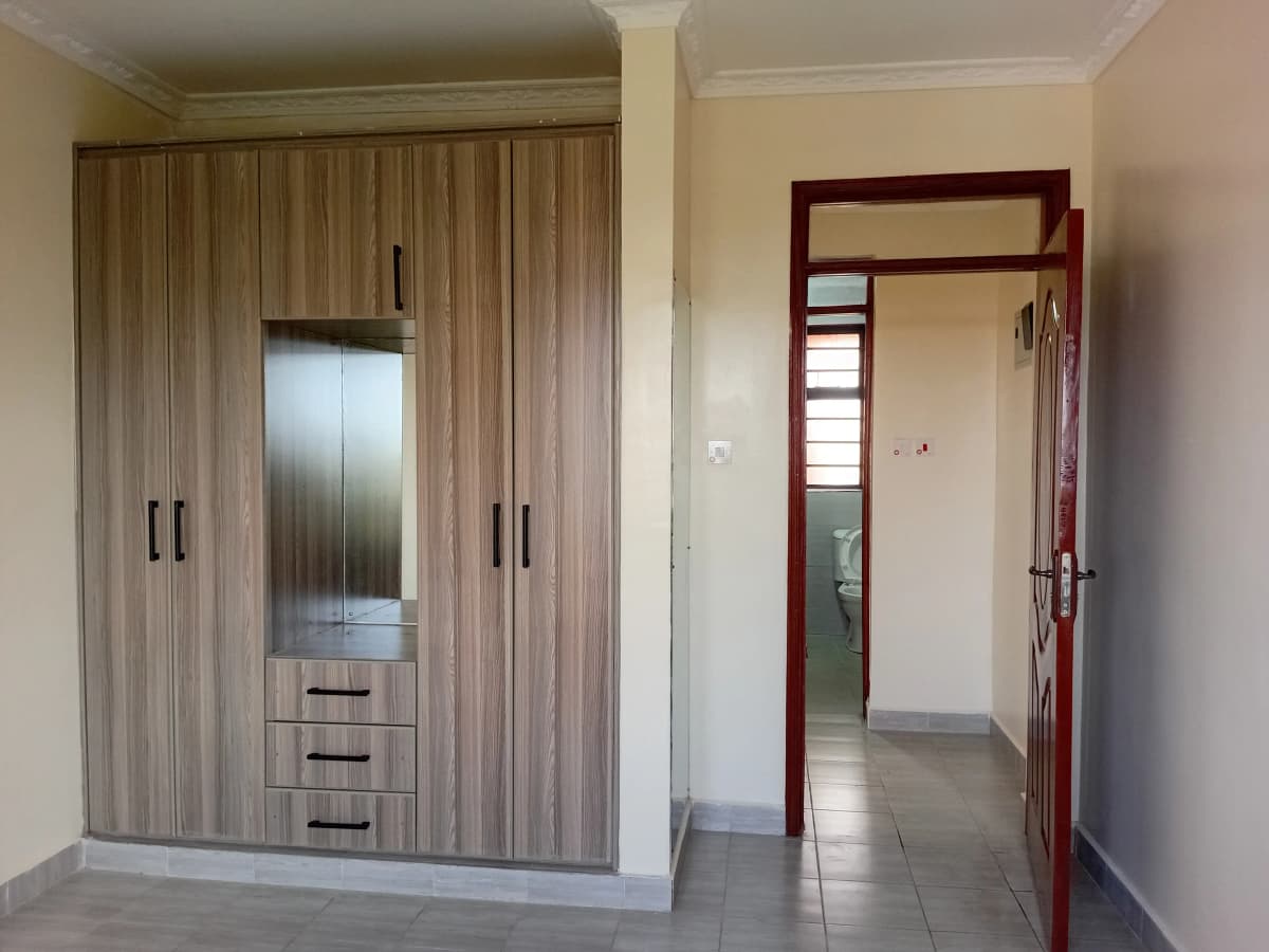 Master bedroom with built-in wooden wardrobe and ensuite entrance