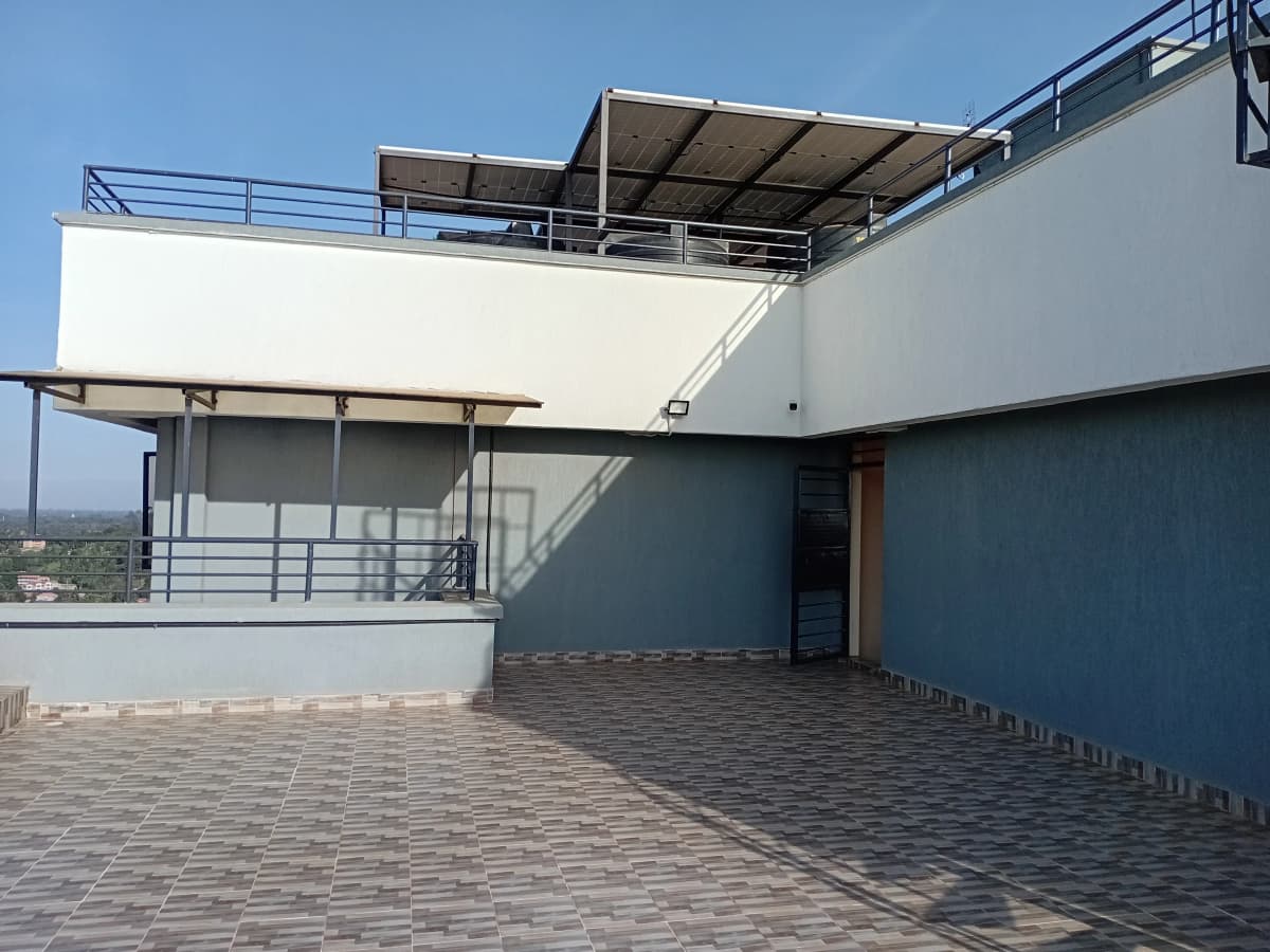 Multi-level rooftop terrace with paved flooring and metal railings