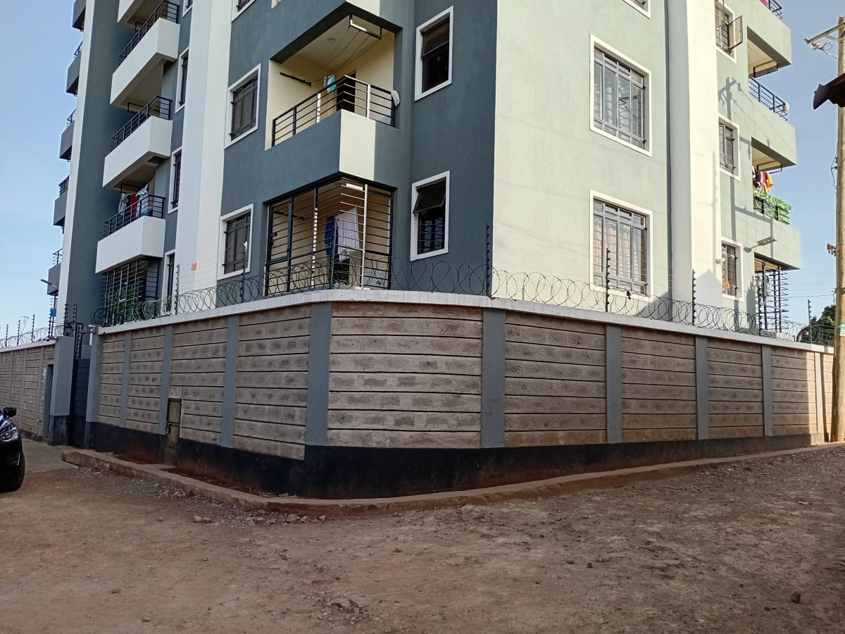 Multi-story residential building with perimeter wall and gate