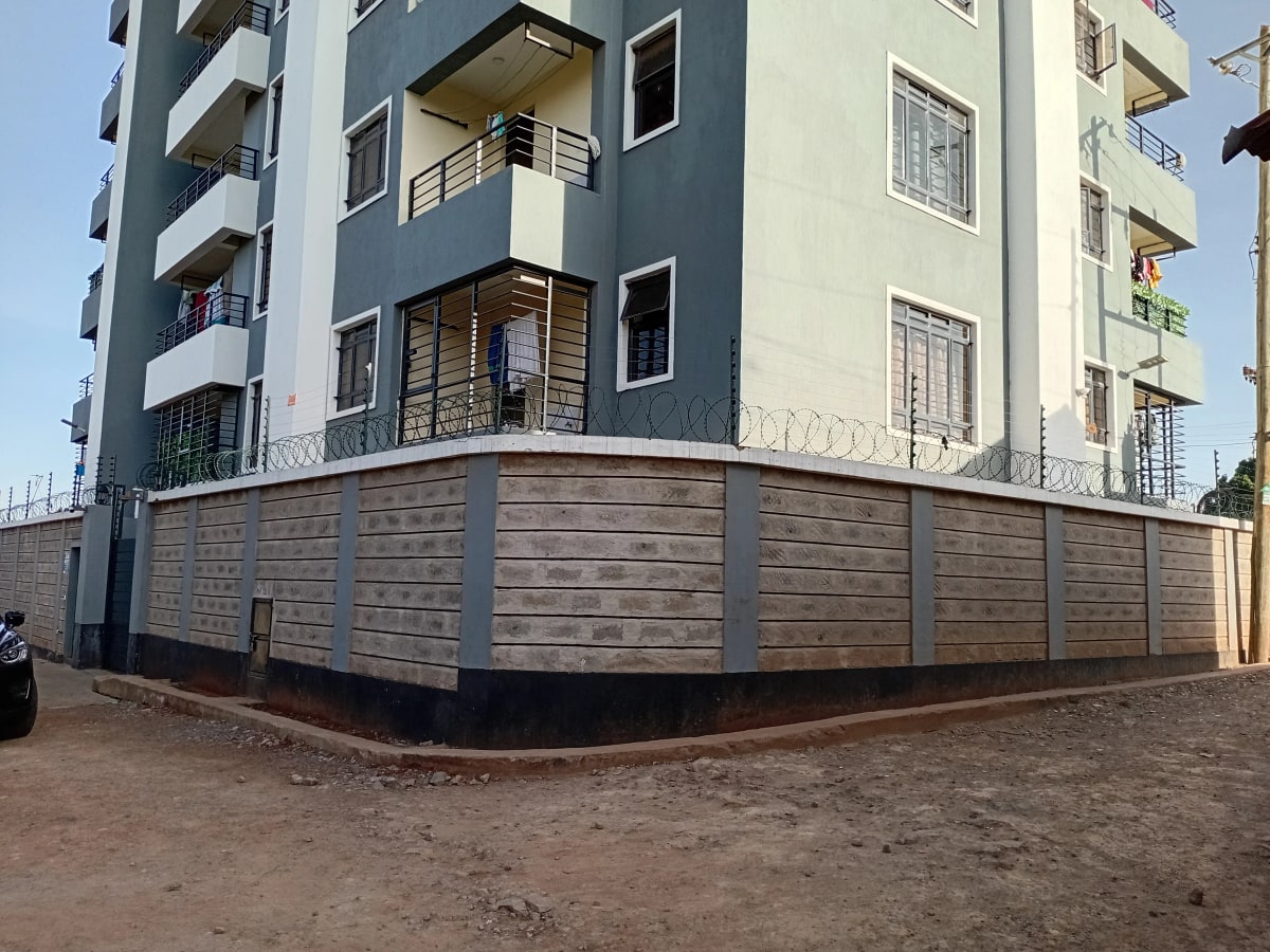 Multi-story residential building with perimeter wall and gate