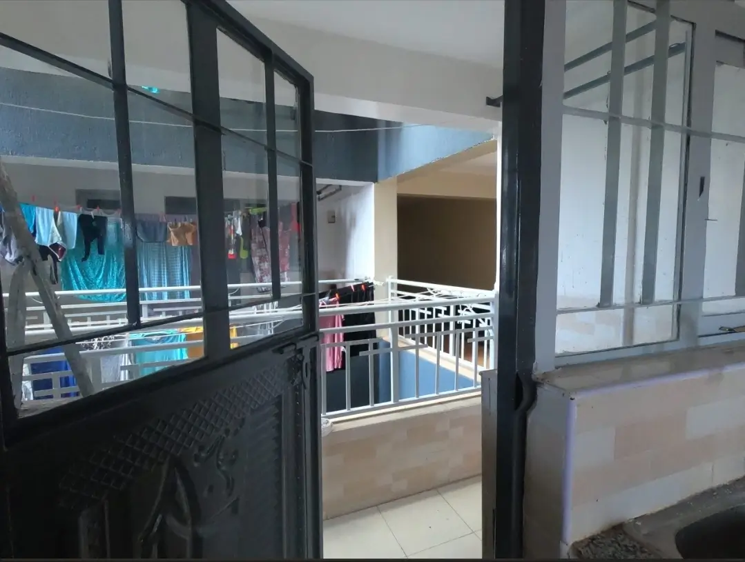 Balcony with black-framed glass doors overlooking city landscape